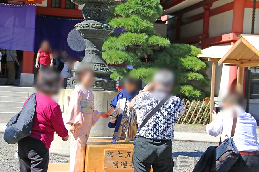 日枝神社 碁盤の儀用の開運碁盤とそこで記念撮影を行う七五三ご家族の様子（その1）