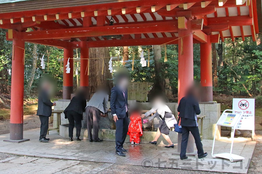 鹿島神宮 手水舎で手水する七五三ちゃんとそのご家族の様子